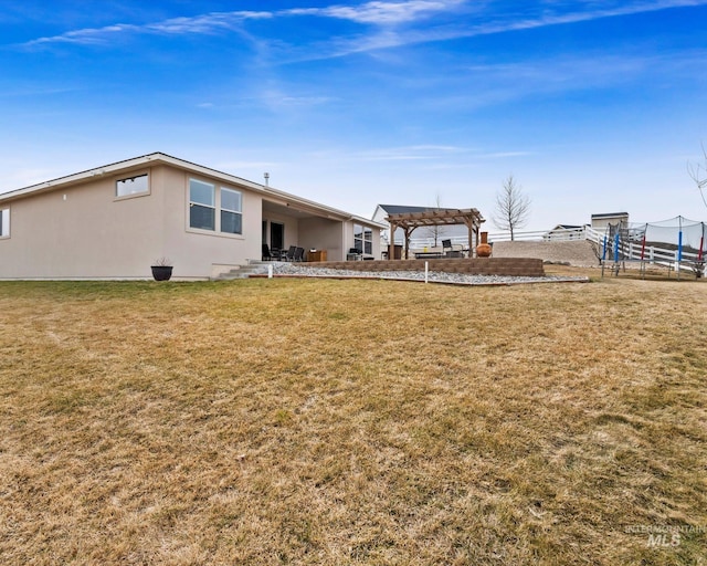 rear view of property with stucco siding, a pergola, fence, a yard, and a patio area