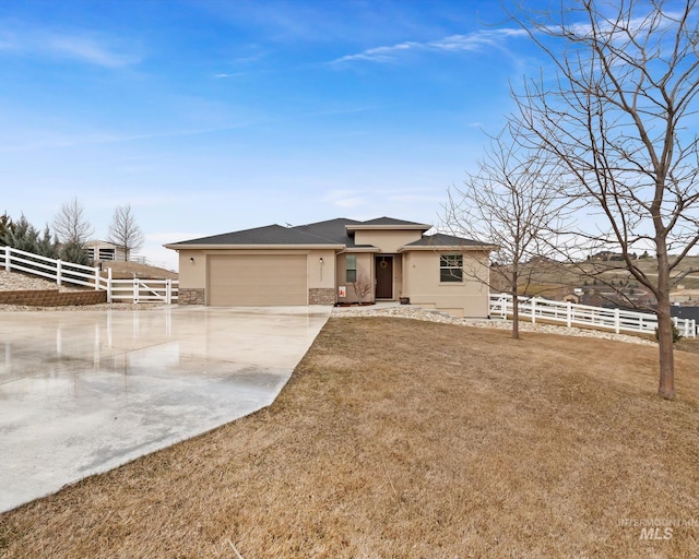 view of front of home featuring fence, a garage, driveway, and stucco siding