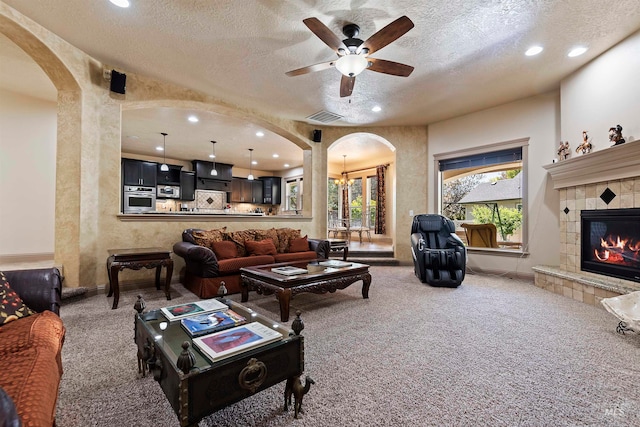 4315 N Nuova Ave, Meridian, ID 83646 - living area with arched walkways, carpet flooring, visible vents, and a tiled fireplace