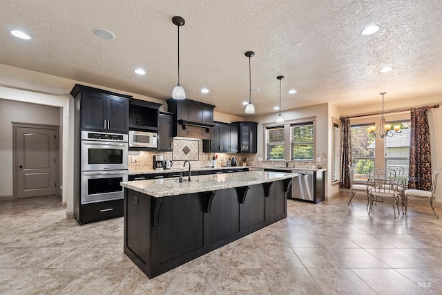 4315 N Nuova Ave, Meridian, ID 83646 - kitchen featuring a center island with sink, a breakfast bar area, stainless steel appliances, and backsplash