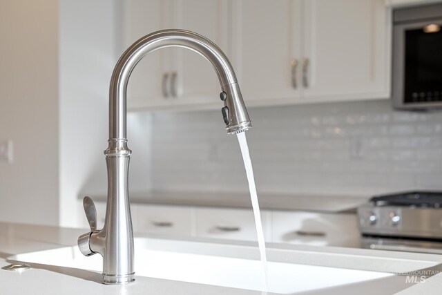 details featuring white cabinetry, light countertops, and a sink