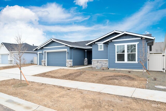 view of front of house featuring stone siding, board and batten siding, driveway, and a garage