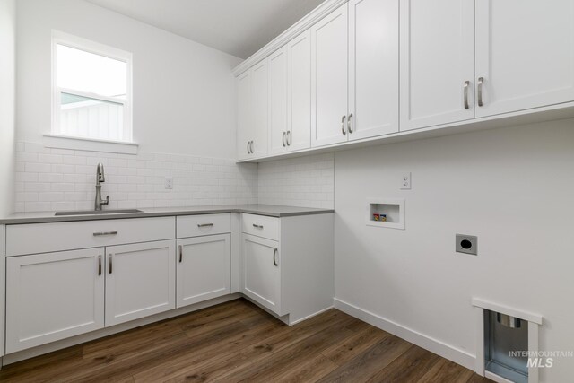 laundry area featuring hookup for a washing machine, dark wood finished floors, a sink, electric dryer hookup, and cabinet space
