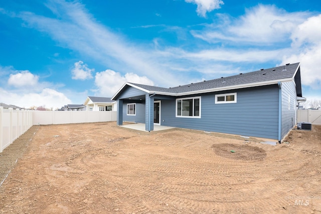 rear view of house featuring a fenced backyard, central AC, and a patio