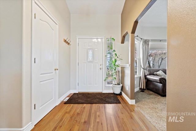 foyer featuring baseboards and wood finished floors