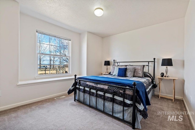 carpeted bedroom featuring visible vents, a textured ceiling, and baseboards