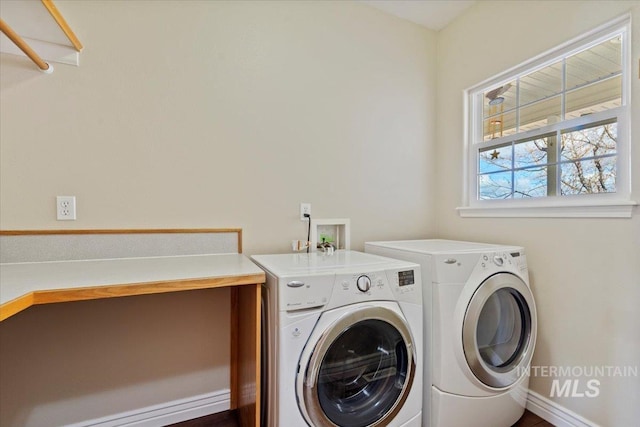 washroom featuring washer and dryer, laundry area, and baseboards