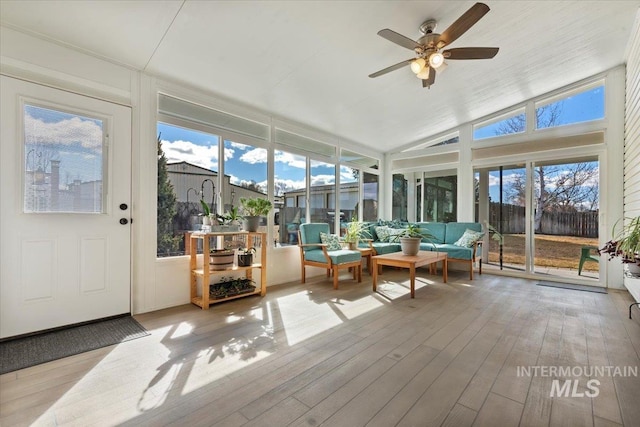 sunroom featuring lofted ceiling and a ceiling fan