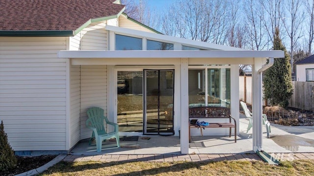 exterior space with roof with shingles and fence