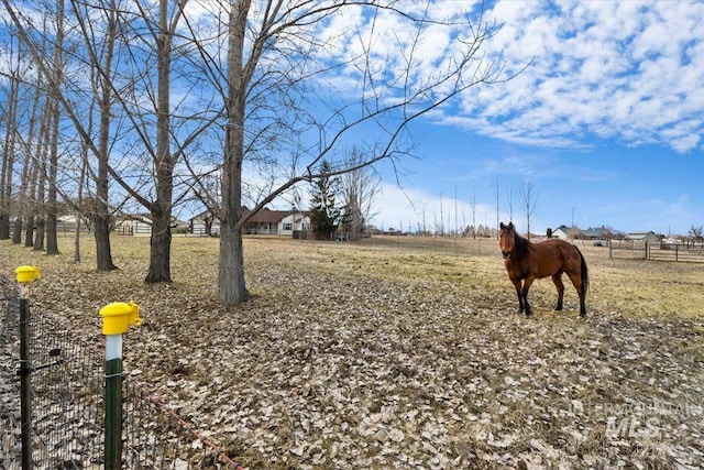 view of yard featuring fence and a rural view