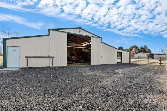 view of pole building with gravel driveway