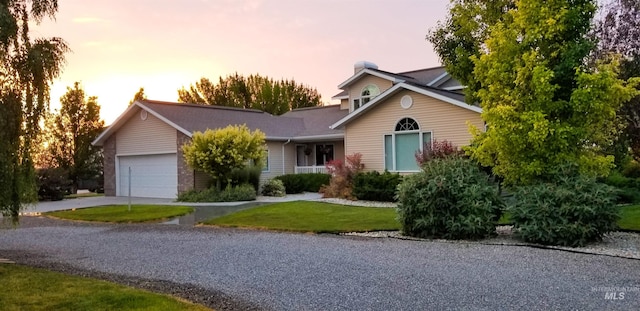 view of front of house with a garage and a yard