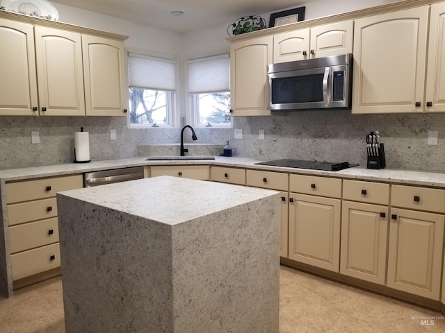 kitchen with a center island, appliances with stainless steel finishes, sink, and decorative backsplash