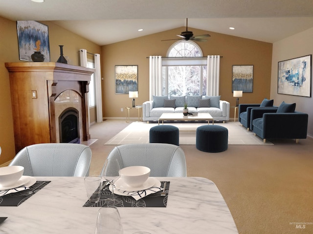 dining area featuring vaulted ceiling, light carpet, ceiling fan, and a fireplace