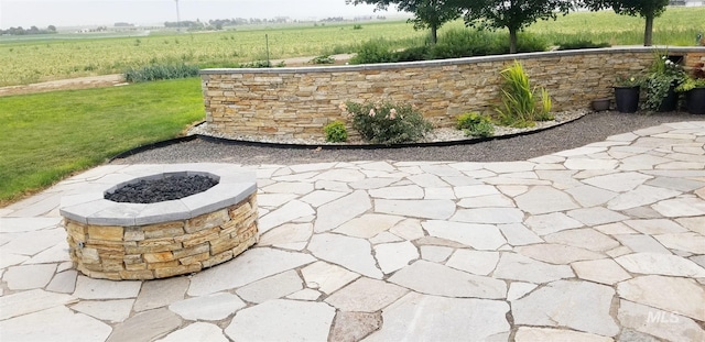 view of patio / terrace featuring a rural view and an outdoor fire pit