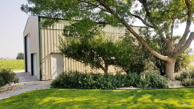 view of home's exterior with an outbuilding and a yard