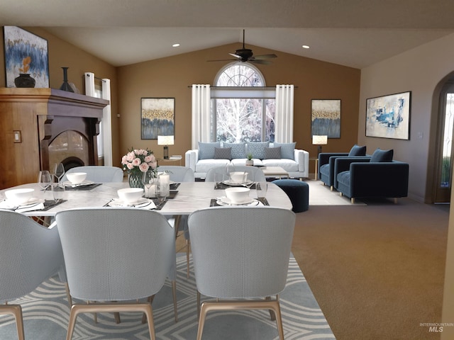 dining space with vaulted ceiling, light carpet, and ceiling fan