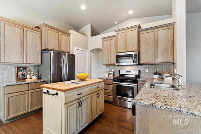 kitchen with stainless steel appliances, sink, wooden counters, light brown cabinetry, and backsplash