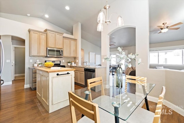 kitchen with hardwood / wood-style flooring, light brown cabinets, appliances with stainless steel finishes, and lofted ceiling