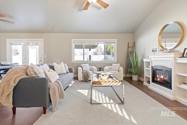 living room featuring lofted ceiling, hardwood / wood-style flooring, and ceiling fan