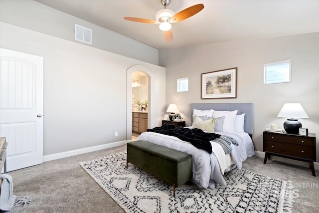 bedroom with connected bathroom, lofted ceiling, light colored carpet, and ceiling fan