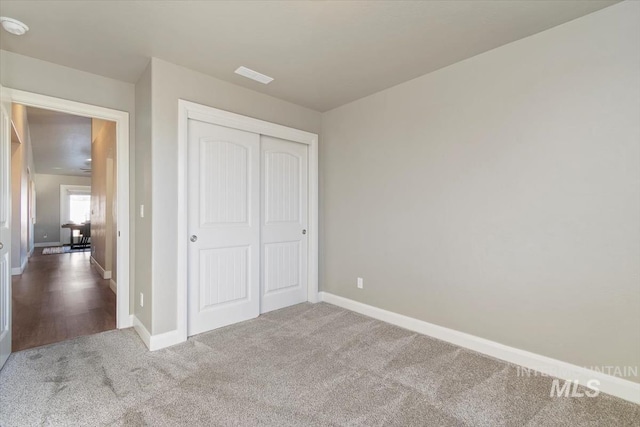 unfurnished bedroom with a closet and carpet flooring