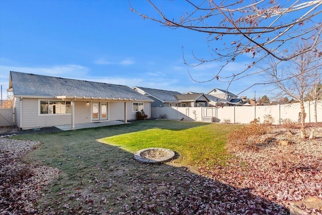 back of house with a patio and a lawn