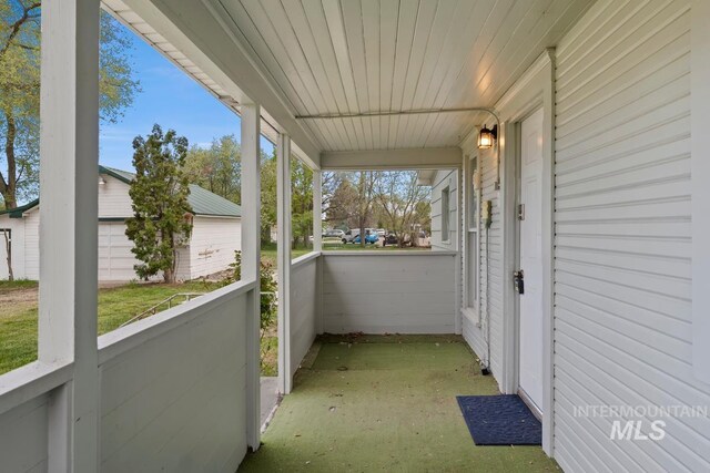 exterior space featuring covered porch and an outbuilding