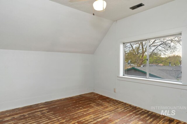 bonus room featuring lofted ceiling, visible vents, baseboards, wood-type flooring, and a ceiling fan