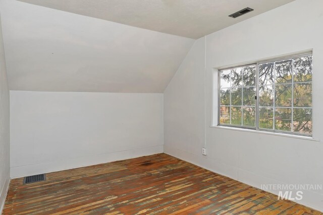 bonus room featuring visible vents, wood-type flooring, and vaulted ceiling