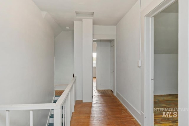 hall featuring attic access, an upstairs landing, and light wood-style floors