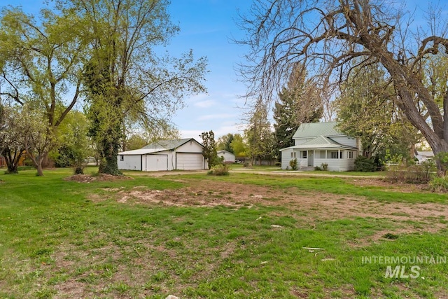 view of yard with a garage and an outbuilding