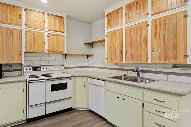 kitchen featuring white appliances, decorative backsplash, open shelves, light countertops, and a sink