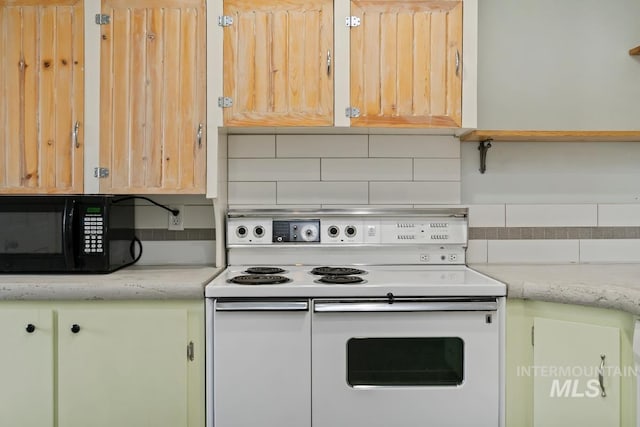 kitchen with black microwave, decorative backsplash, and white electric range