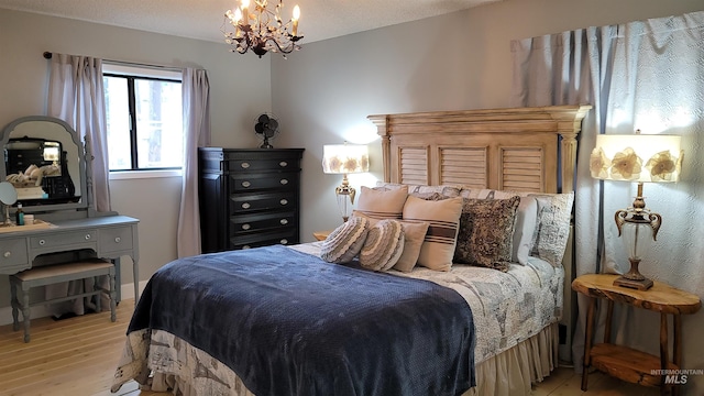 bedroom featuring light wood-type flooring and a chandelier