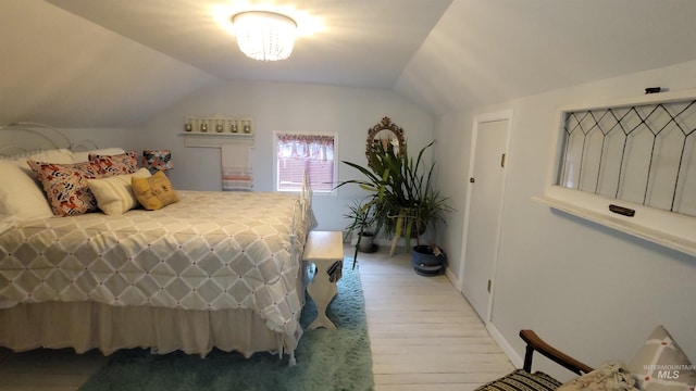 bedroom with lofted ceiling and light wood-style flooring