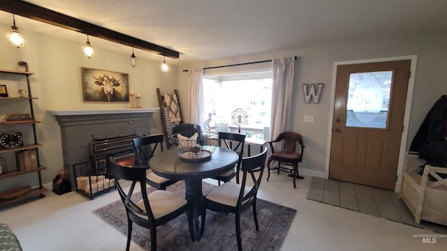 dining room with beam ceiling, a fireplace, and baseboards