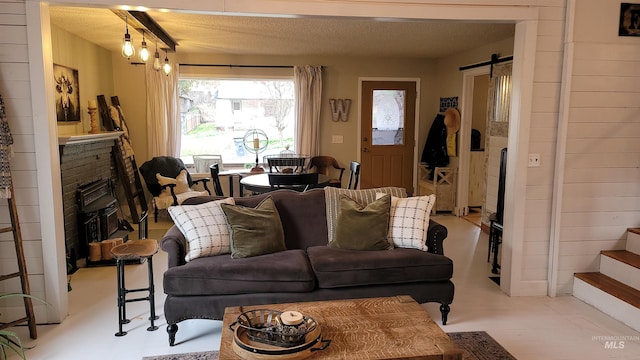 living area featuring stairway, a fireplace, a textured ceiling, and a barn door