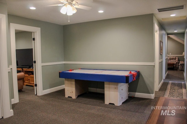 recreation room with dark colored carpet and ceiling fan