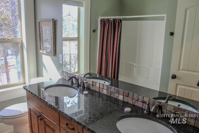 bathroom with vanity, curtained shower, and toilet