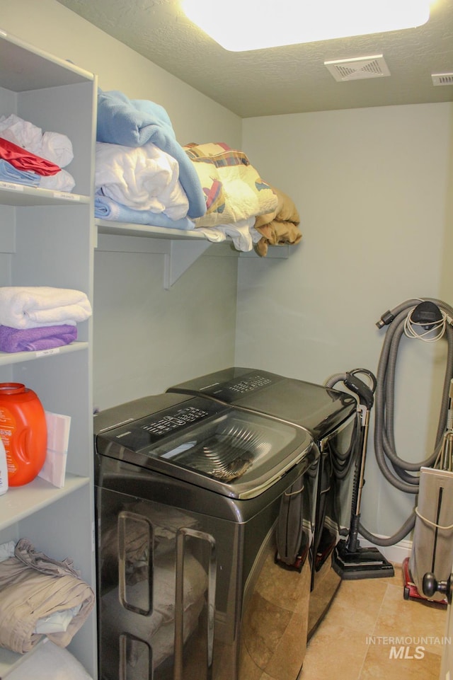 washroom featuring light tile patterned floors and washing machine and clothes dryer