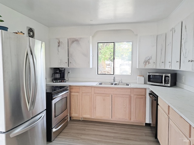 207 N Main St, Homedale, ID 83628 - kitchen featuring appliances with stainless steel finishes, a sink, light brown cabinetry, and light wood-type flooring