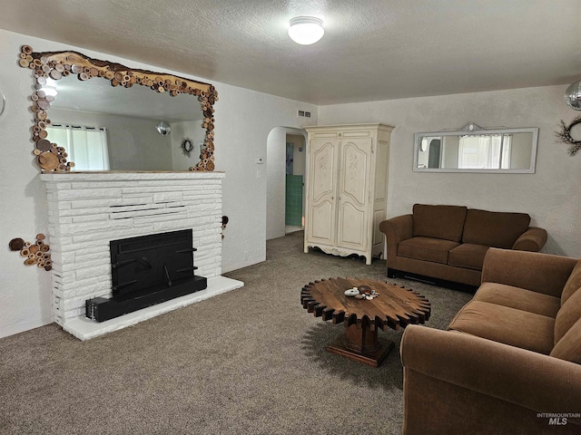 207 N Main St, Homedale, ID 83628 - living area with arched walkways, carpet, a fireplace with raised hearth, and a textured ceiling
