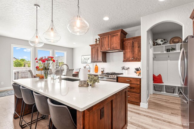 1670 Mary Hill Ave, Middleton, ID 83644 - kitchen with a sink, stainless steel appliances, light wood-style floors, an island with sink, and light countertops