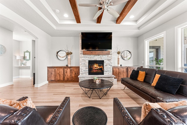 1670 Mary Hill Ave, Middleton, ID 83644 - living area with light wood finished floors, a ceiling fan, a stone fireplace, baseboards, and arched walkways