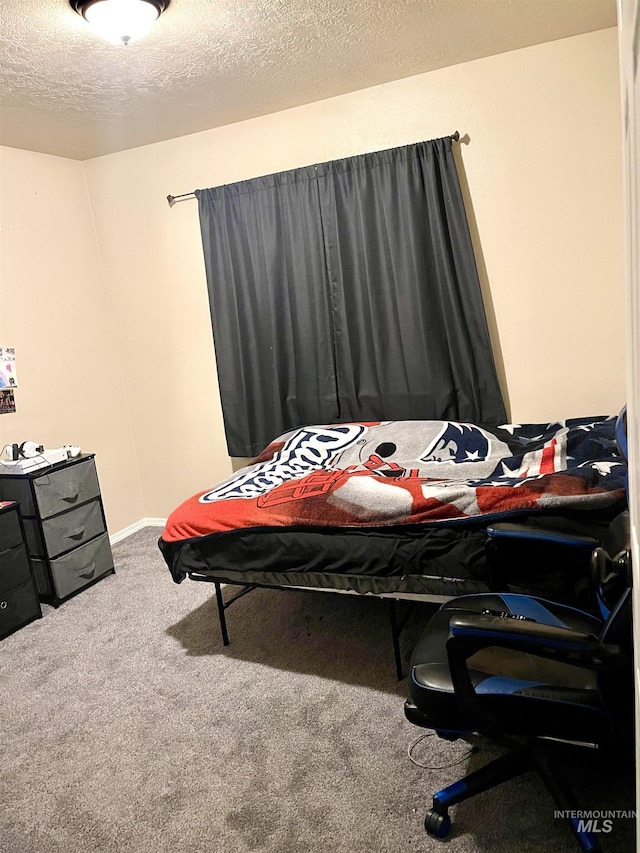 bedroom with carpet and a textured ceiling