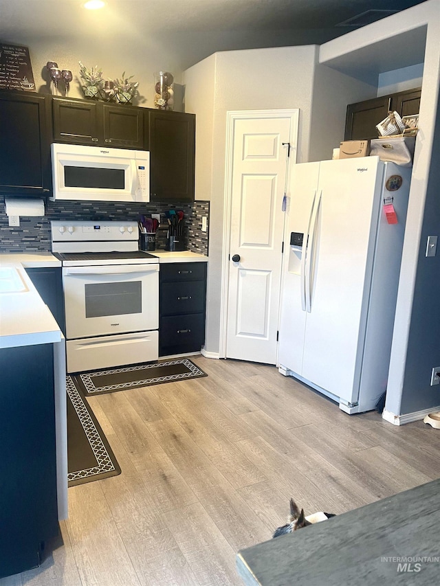 kitchen featuring tasteful backsplash, sink, white appliances, and light wood-type flooring