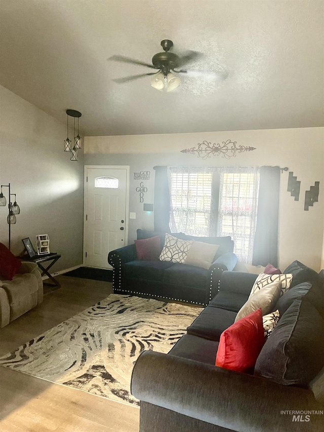 living room with ceiling fan, wood-type flooring, and lofted ceiling