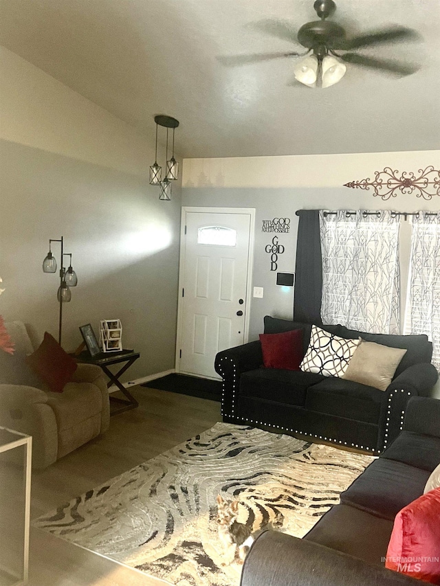 living room featuring ceiling fan and lofted ceiling