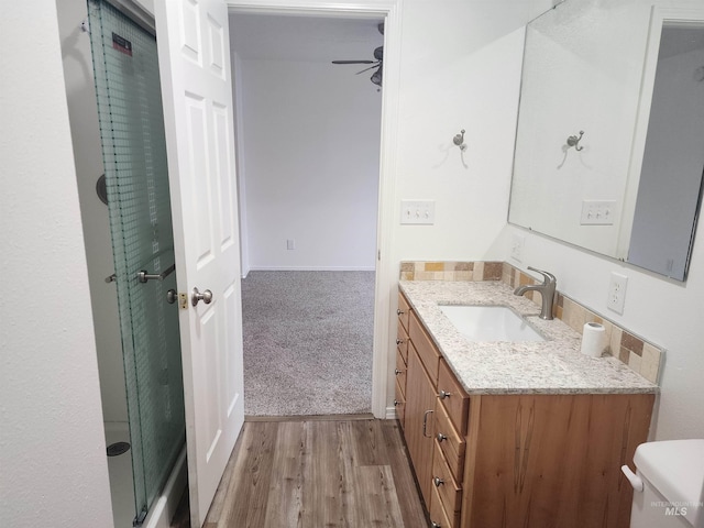 bathroom featuring ceiling fan, hardwood / wood-style floors, and vanity